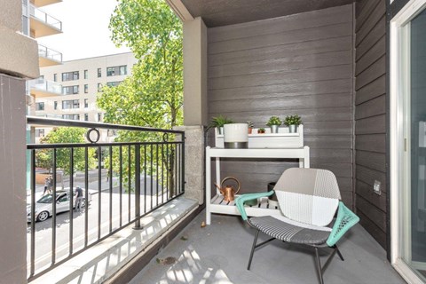a patio with a chair and a table on a balcony
