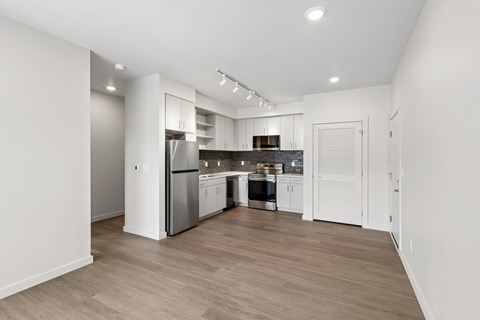 A modern kitchen with wooden floors and white walls.