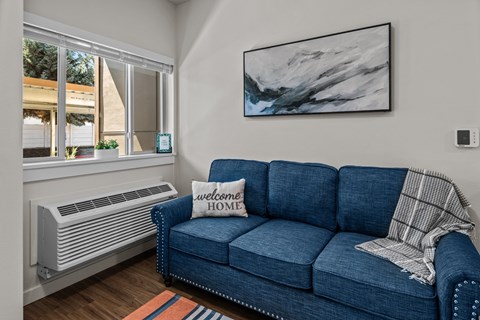 a living room with a blue couch and a window