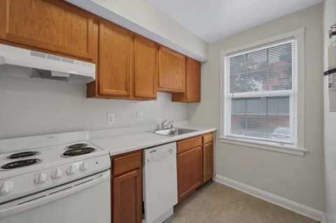 A kitchen with white appliances and wooden cabinets.
