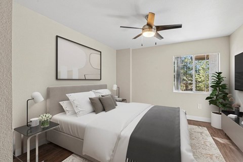 A bedroom with a large bed and a ceiling fan.