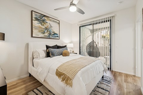 A bedroom with a large bed and a painting on the wall.