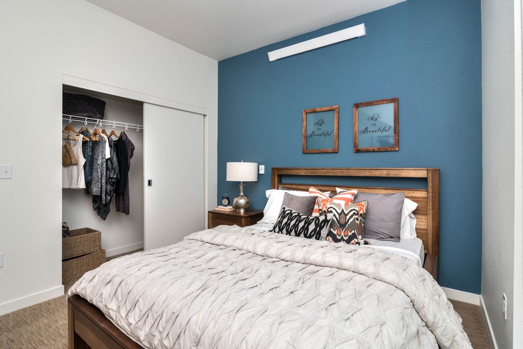 a bedroom with a large bed in front of a blue wall