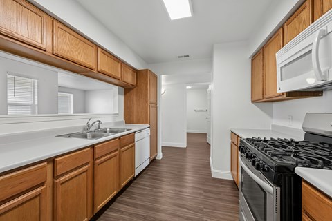 A kitchen with wooden cabinets and a black stove top oven.