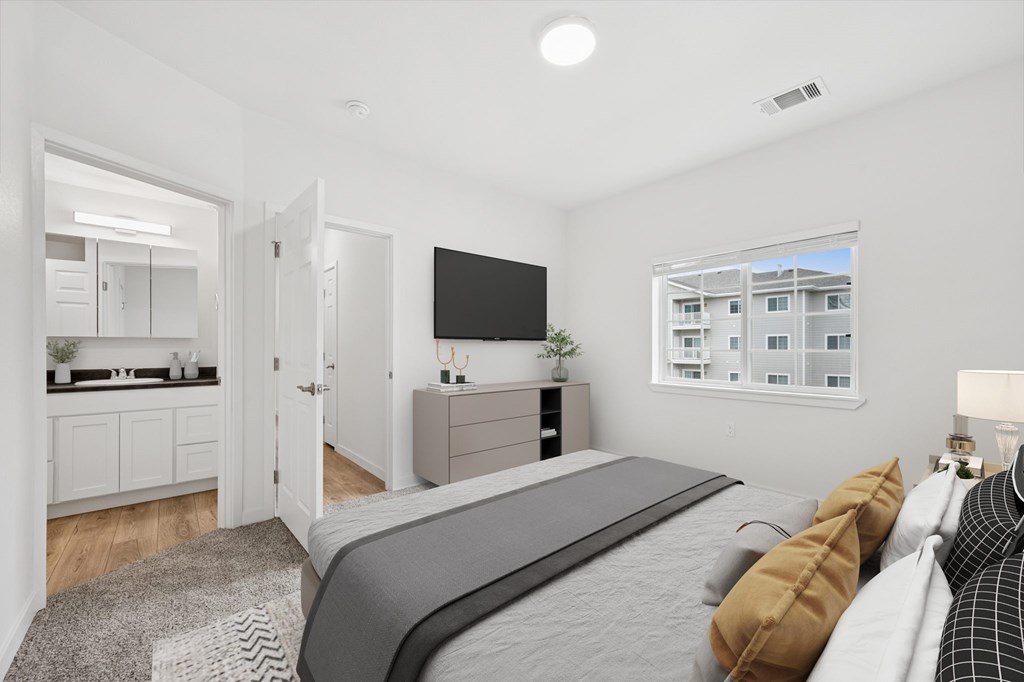 A modern bedroom with a large bed and a flat-screen TV.