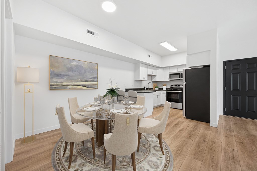 A modern dining room with a round table set for six.