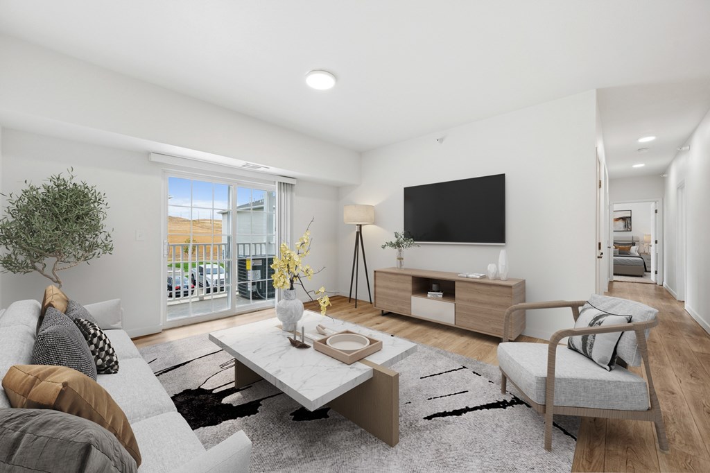 A modern living room with a grey sofa, a white coffee table, and a flat-screen TV.