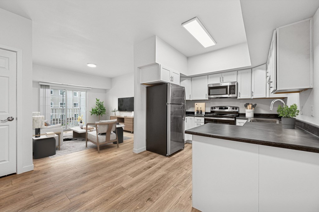 A modern kitchen with a refrigerator, stove, and microwave.