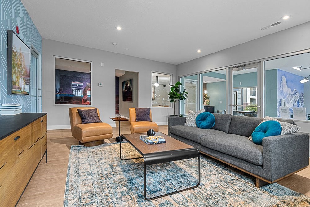 a living room with a gray couch and two orange chairs