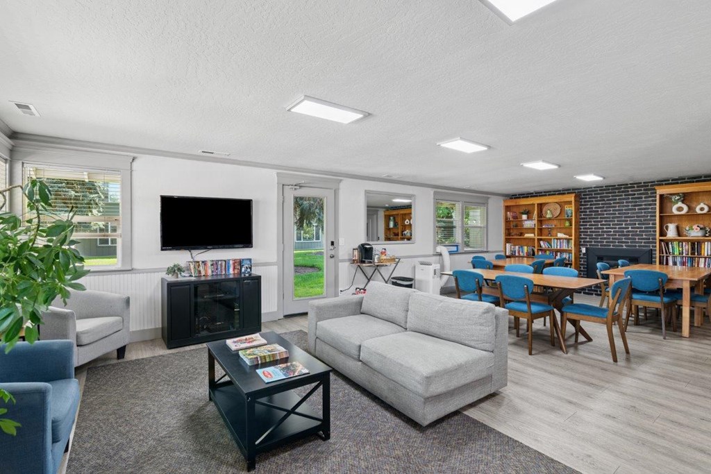 A living room with a grey couch, a black coffee table, and a television.