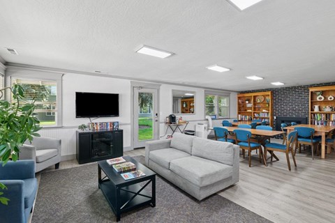 A living room with a grey couch, a black coffee table, and a television.