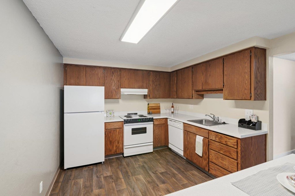 A kitchen with wooden cabinets and white appliances.