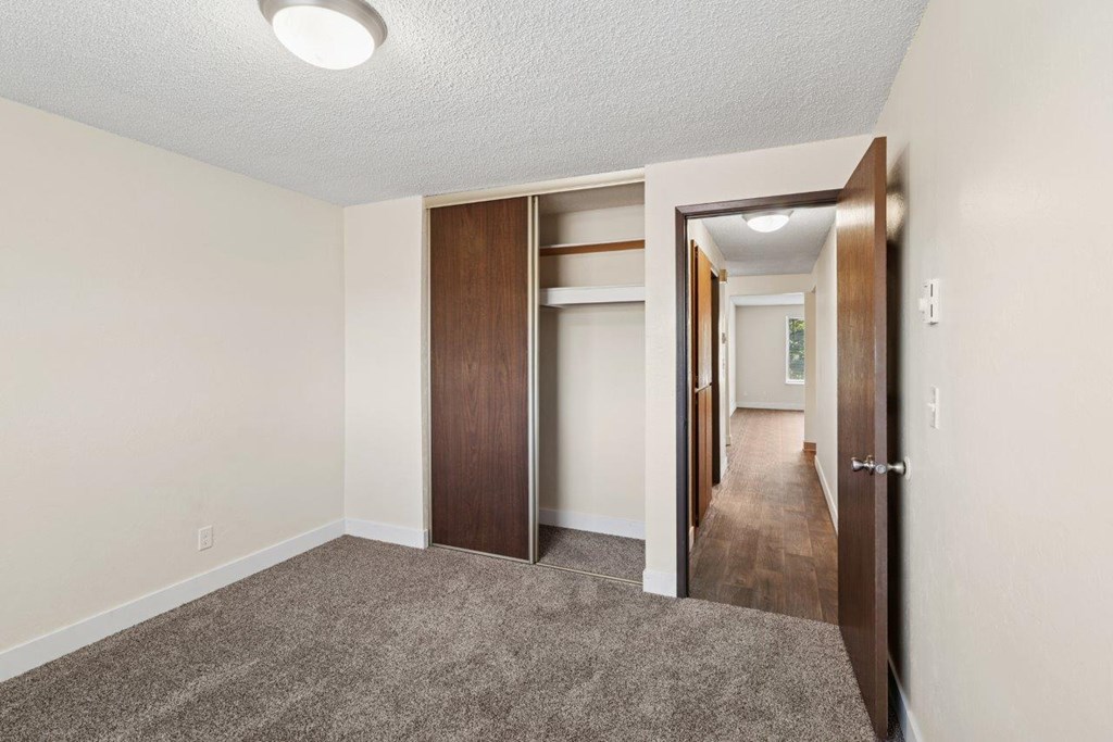 A room with a carpeted floor and a white ceiling with a light fixture.
