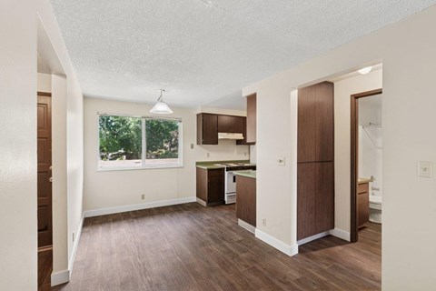 A kitchen area with brown cabinets and a window.