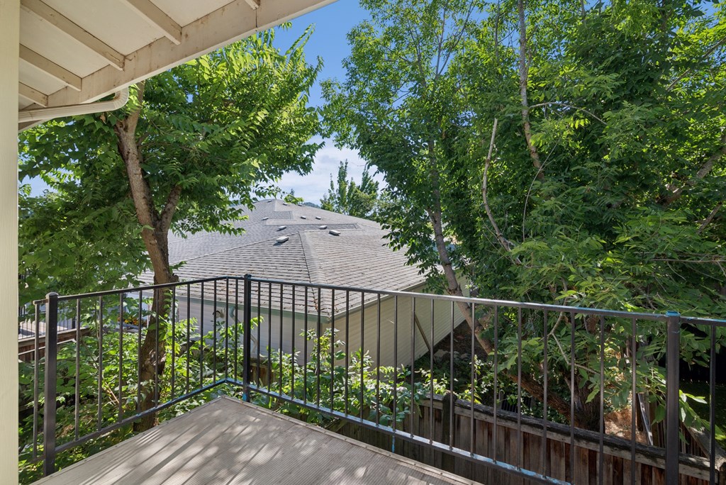 A balcony with a metal railing and a roof with a tiled surface.