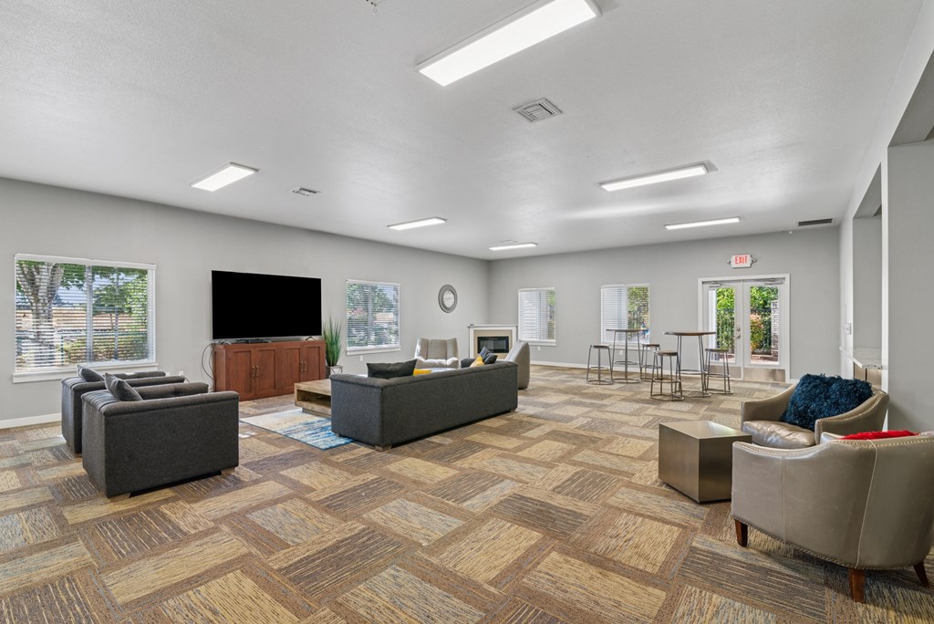 A spacious waiting room with a variety of seating options and a flat screen TV.