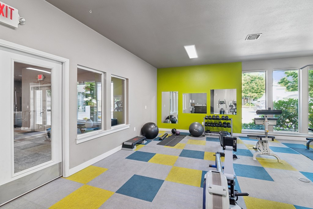 A gym with a variety of equipment including a rowing machine.