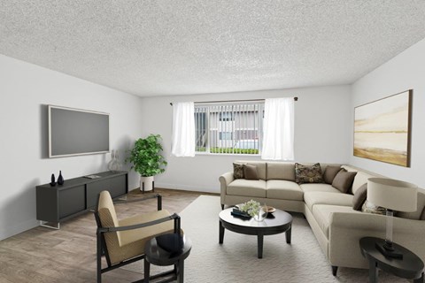 A living room with a grey sofa, a brown armchair, a coffee table, and a flat screen TV mounted on the wall.