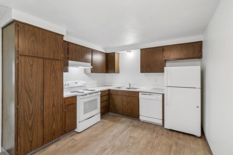 A kitchen with white appliances and wooden cabinets.