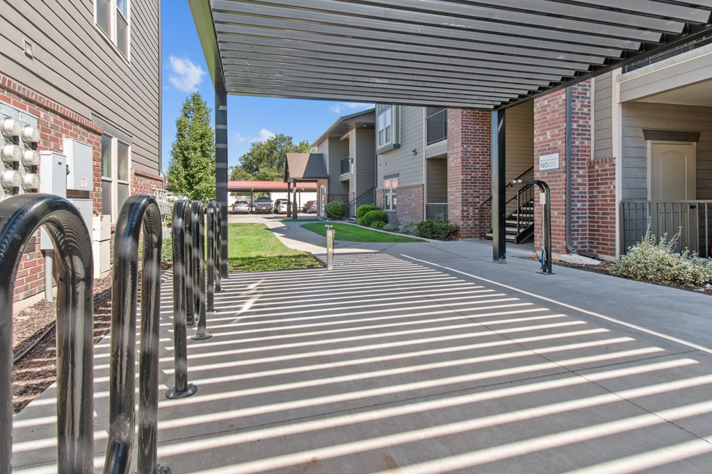 a covered walkway at the whispering winds apartments in pearland, tx