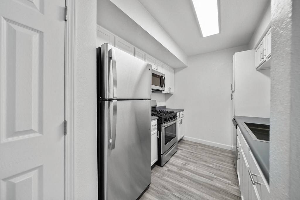 a kitchen with stainless steel appliances and white cabinets