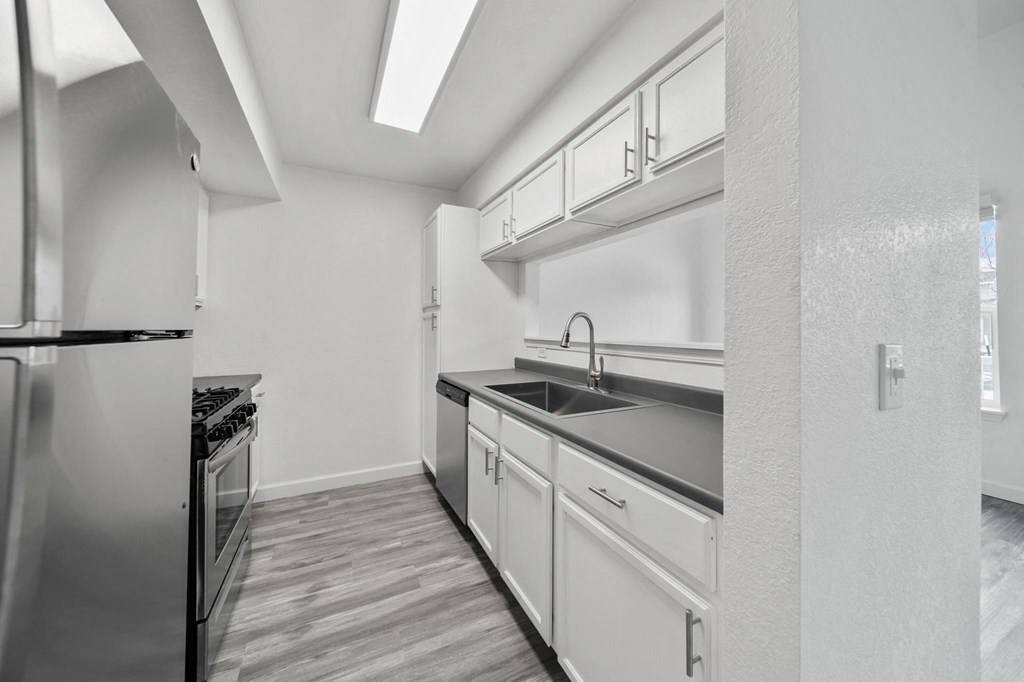 a kitchen with white cabinetry and a wooden floor