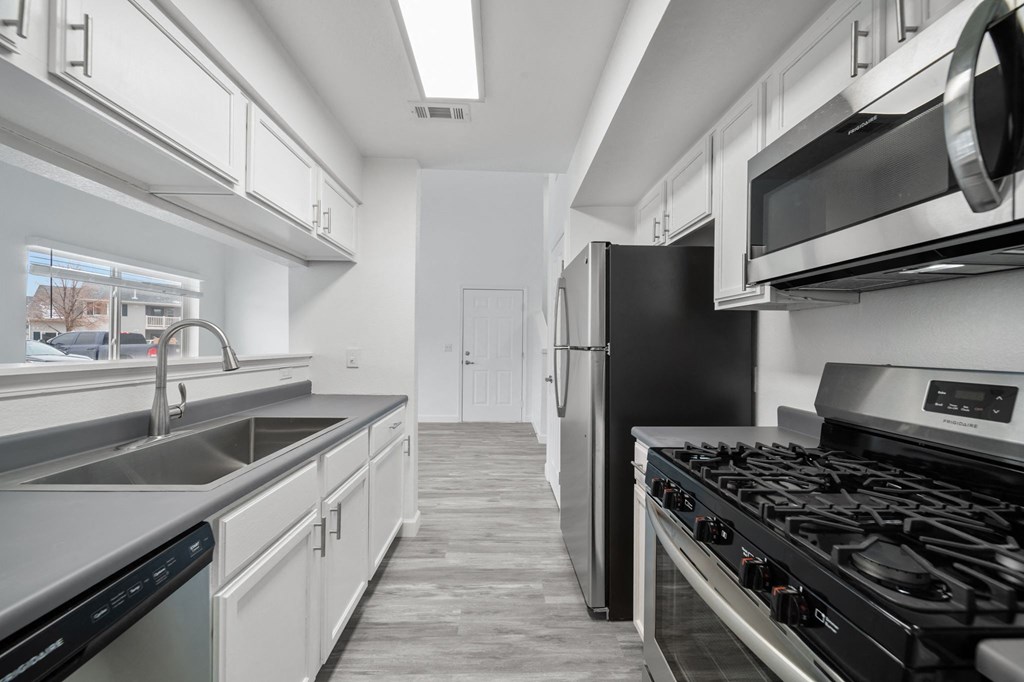 a kitchen with white cabinets and stainless steel appliances