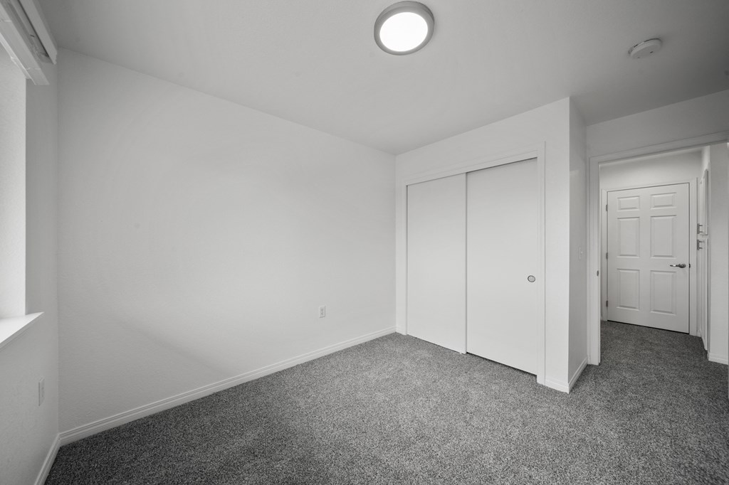 a bedroom with white walls and carpet