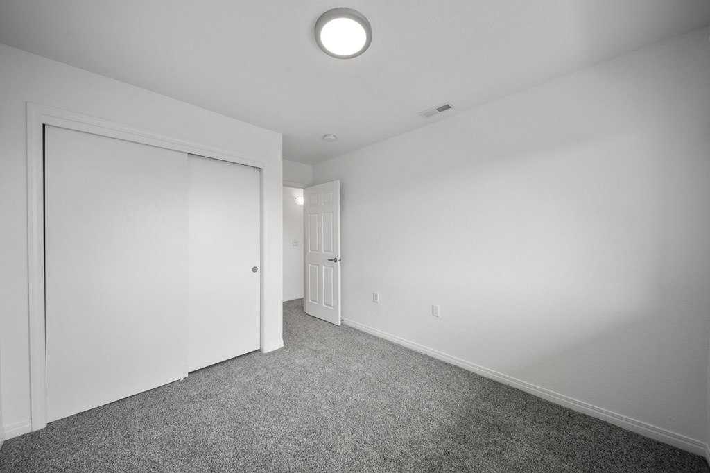 a bedroom with white walls and carpet