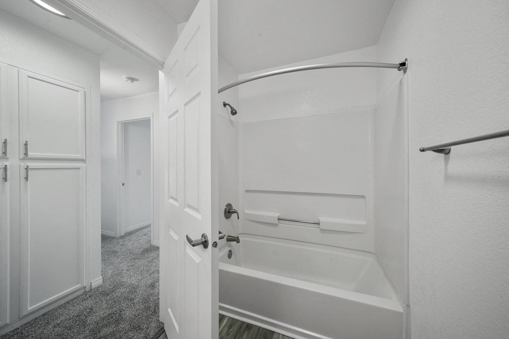 a bathroom with a white door and a white bathtub