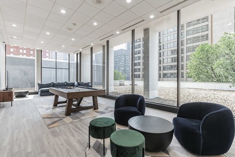 A modern living room with a long table and black chairs.