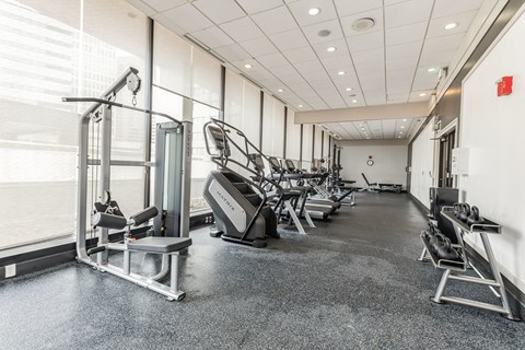 A gym with a variety of equipment including treadmills, weights, and exercise machines.