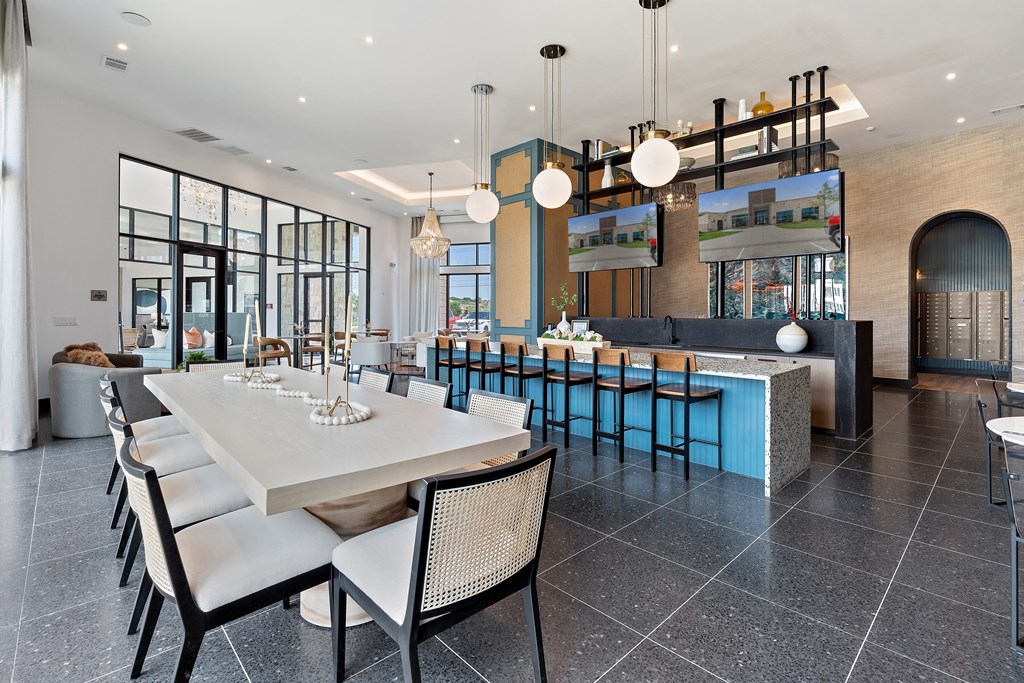 A modern dining room with a long table and chairs.