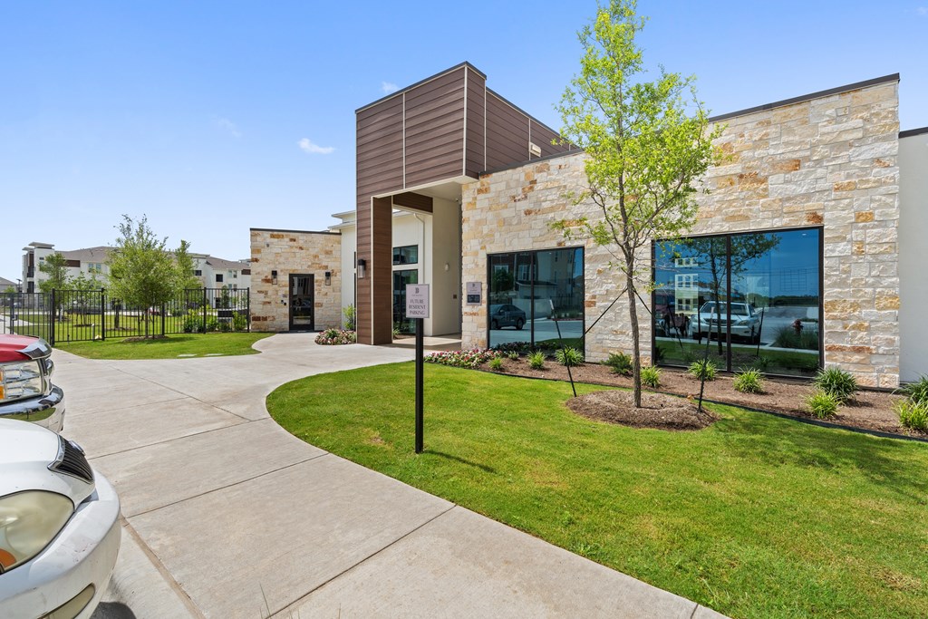 A modern building with a stone facade and a tree in front.