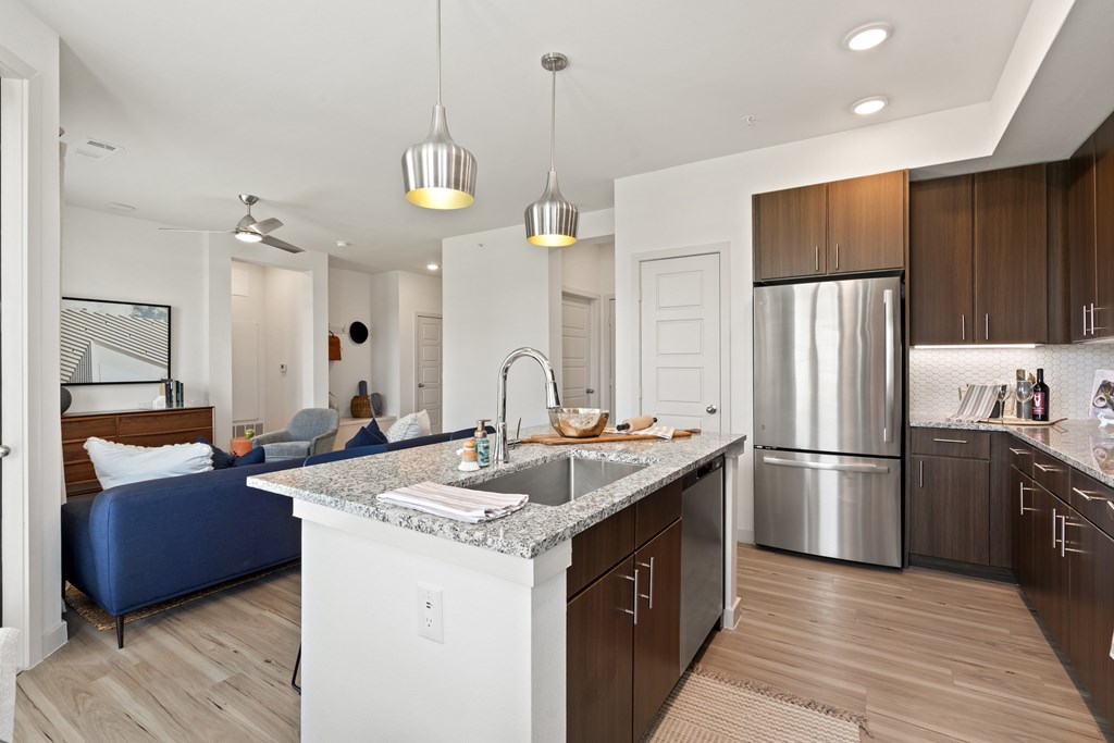 A kitchen with a marble countertop and stainless steel appliances.