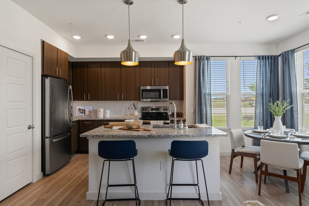 A modern kitchen with dark wood cabinets and a large island.
