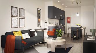 Alexan Gateway living area with a sofa coffee table and a kitchen in the background