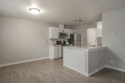 a white kitchen with a counter top and a microwave