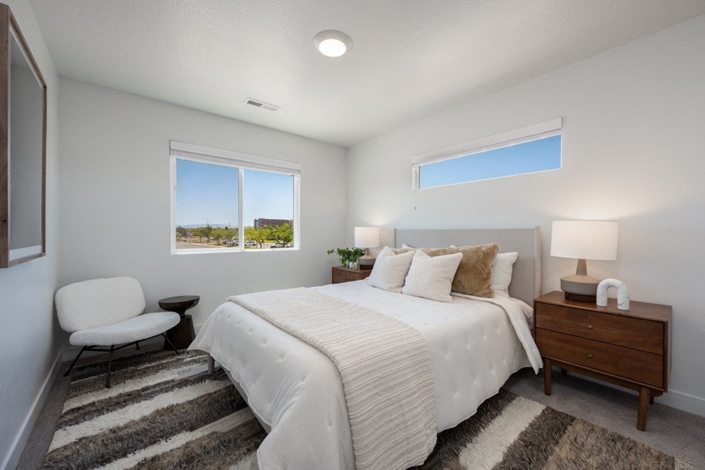 Desert Village Townhomes  white bedroom with a large white bed and two windows