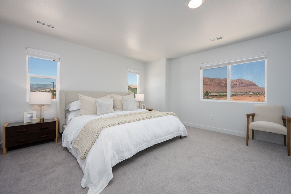 Desert Village Townhomes white bedroom with a large bed and two windows