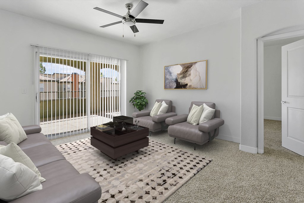 a living room with a couch and chairs and a ceiling fan