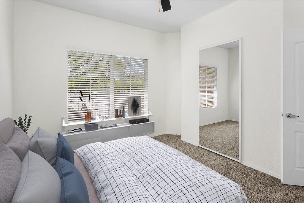 a bedroom with a bed and a window and a mirror