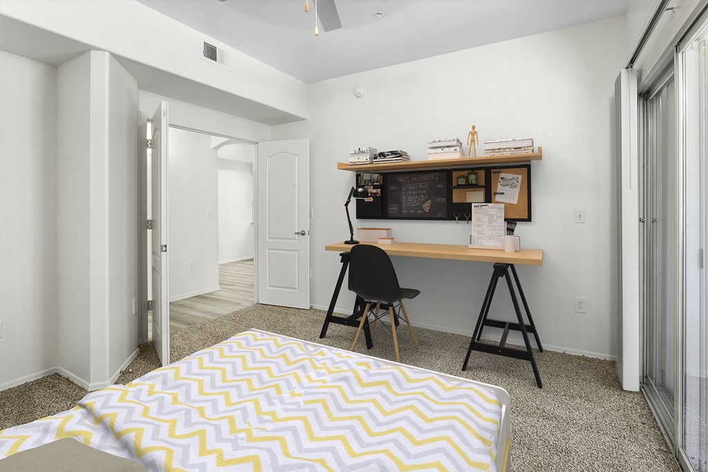 a bedroom with a desk and a bed