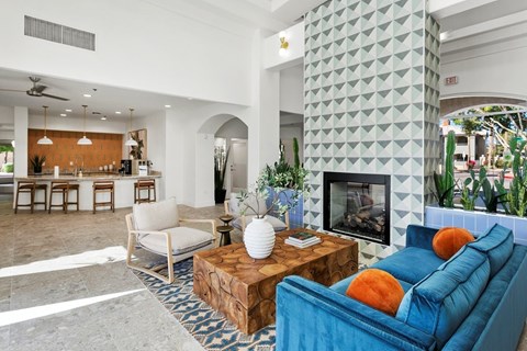 A living room with a blue couch and a fireplace.