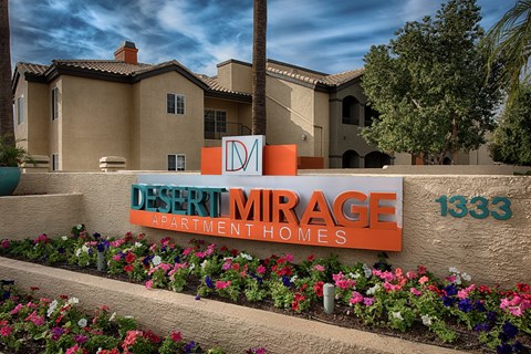 A sign for Desert Mirage Apartment Homes in front of a building.