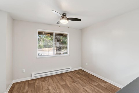 A room with a window and a ceiling fan.