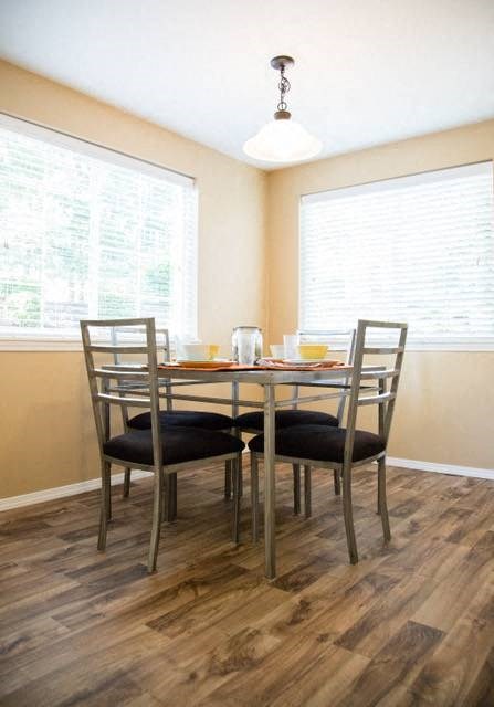 a table and chairs in a room with two windows