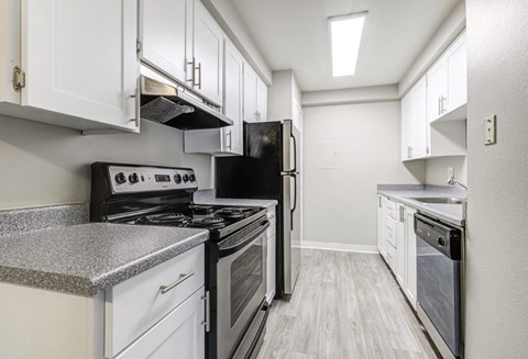 a kitchen with white cabinets and black appliances