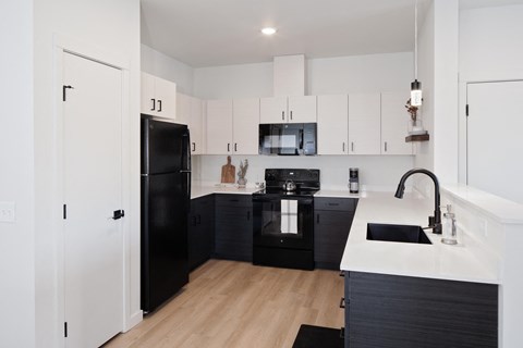 a kitchen with black appliances and white cabinets
