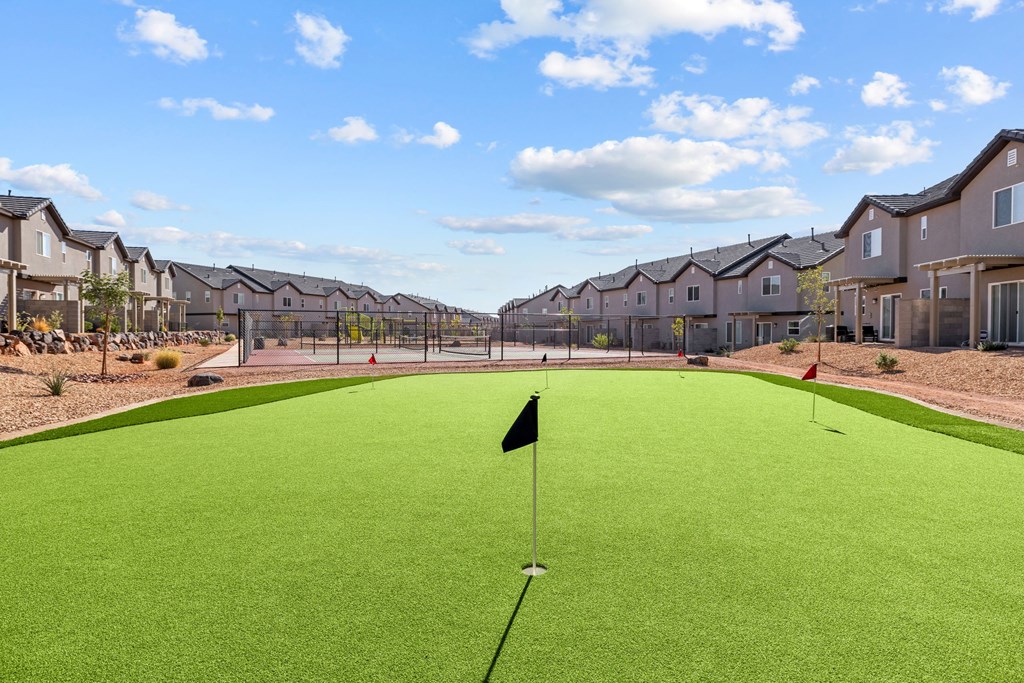 a putting green with houses in the background